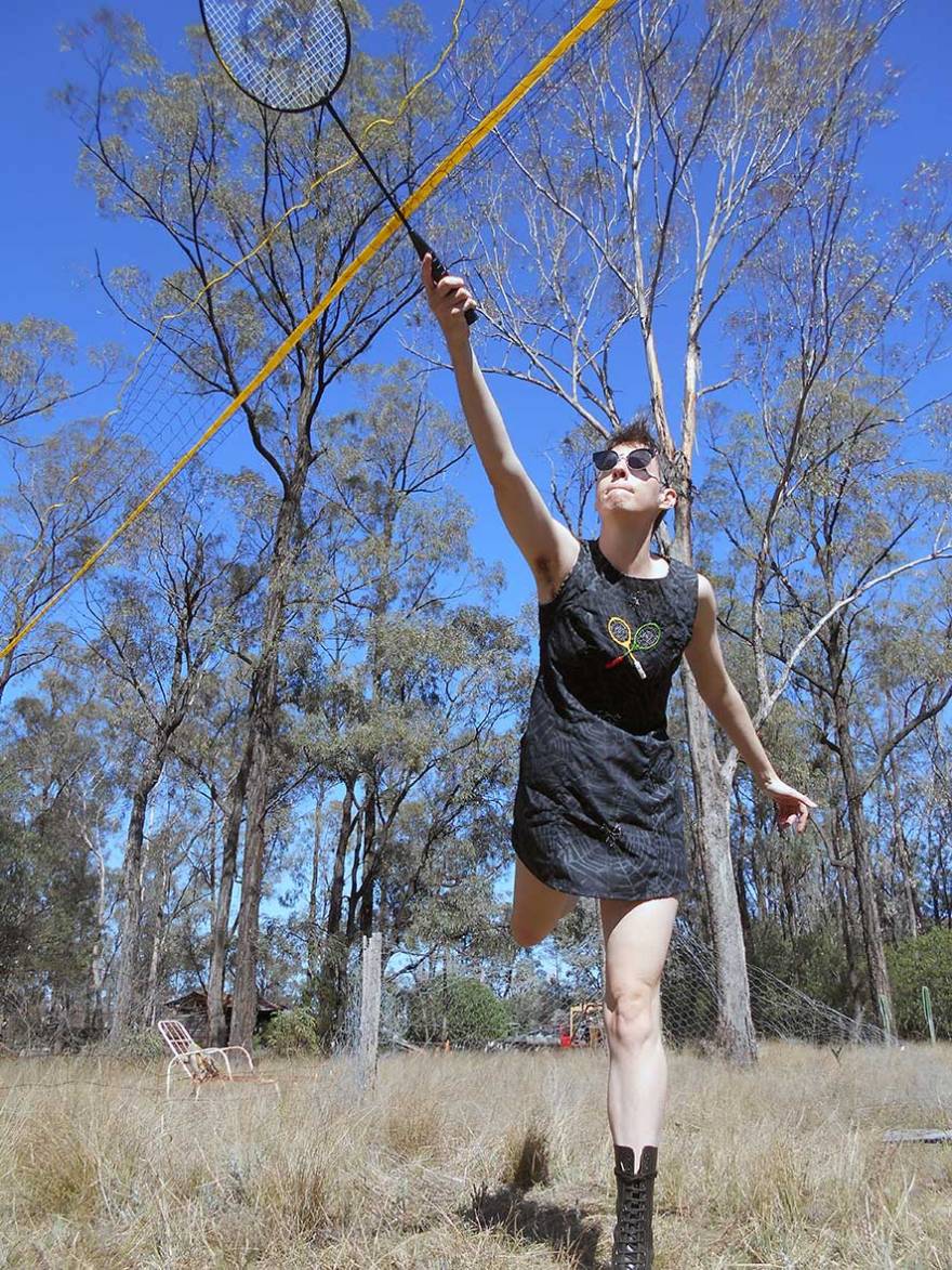 A woman plays badminton in the Australian bush
